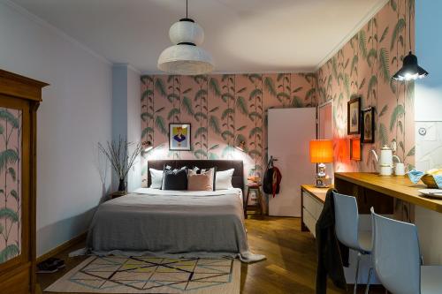 a bedroom with a bed and a desk with chairs at Brilliant Apartments in Berlin