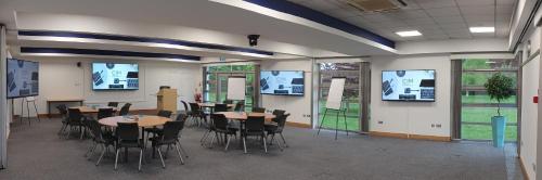 a dining room with tables and chairs and large windows at CIM Business Centre in Maidenhead