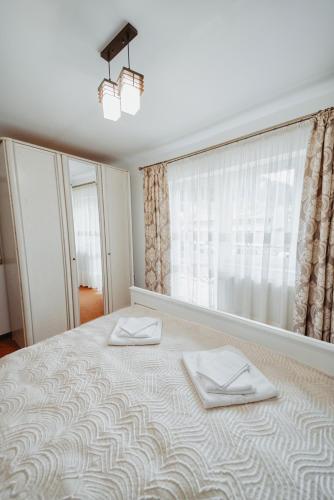 a bedroom with a large bed with two towels on it at Complex Turistic Constantin Bucovina in Câmpulung Moldovenesc