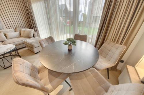 a living room with a table and chairs at Jūra ir TU in Palanga