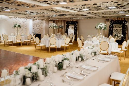 a wedding banquet room with white tables and chairs at Falkensteiner Hotel Belgrade Superior in Belgrade
