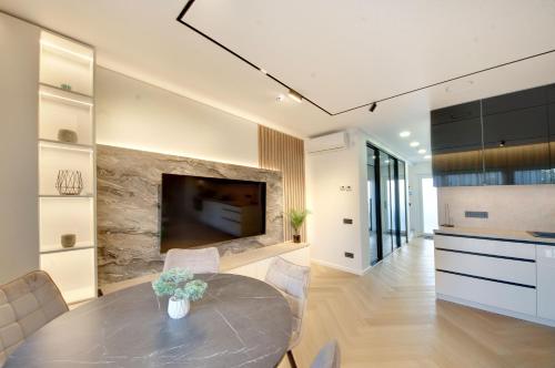 a kitchen and dining room with a table and a tv at Jūra ir TU in Palanga