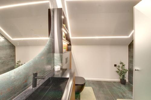 a bathroom with a sink and a staircase at Jūra ir TU in Palanga