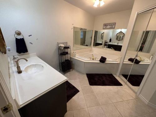 y baño con bañera, lavamanos y bañera. en Magnolia Grace Place, en Kilgore