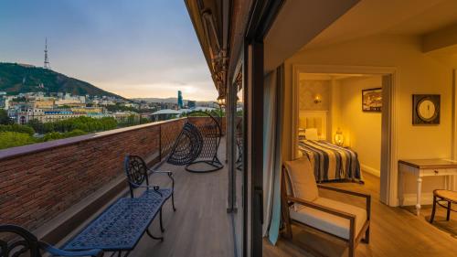 a balcony with two benches and a bed and a bedroom at Hotel Passport Tbilisi in Tbilisi City