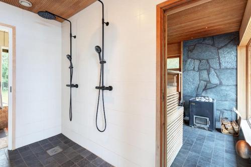 uma cabina de duche na casa de banho com uma parede de pedra em World's End - 2 Luxury Beachfront Villas (425m2) em Mikkeli