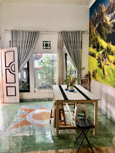 um quarto com uma mesa e um quadro na parede em Ohana Homestay Banyuwangi em Banyuwangi