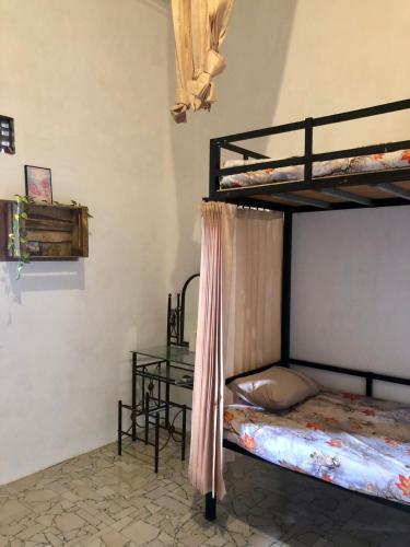 a bedroom with two bunk beds and a table at Ohana Homestay Banyuwangi in Banyuwangi