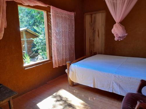 um quarto com uma cama e uma janela em Meemure WENASA HOTEL em Mimure