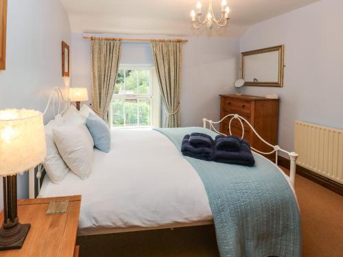 a bedroom with a white bed and a window at Candlelight Cottage in Buxton