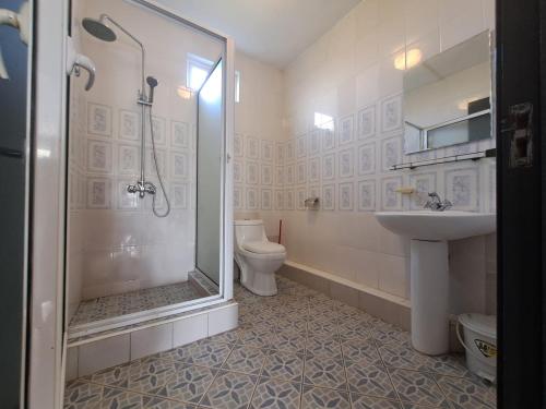 a bathroom with a shower and a toilet and a sink at Spacious Three Bedroom Apartment in Grand Gaube