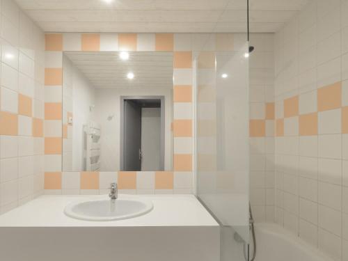 une salle de bain avec un lavabo et un miroir dans l'établissement Studio confort rénové, balcon sud, skis aux pieds - FR-1-181-2556, à Aime La Plagne