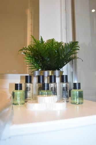 un gruppo di quattro bottiglie di sapone su un bancone del bagno di Hampton Suites Serviced Apartments a Kingston upon Thames