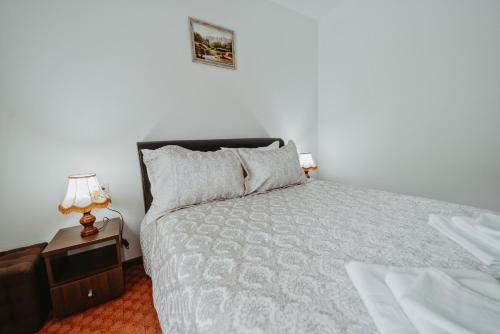 a bedroom with a bed and a table with a lamp at Complex Turistic Constantin Bucovina in Câmpulung Moldovenesc