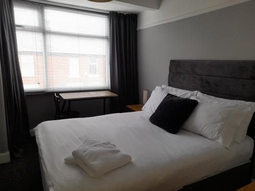 um quarto com uma grande cama branca e 2 almofadas em Bright 4-Bed house 15 min to Manchester Centre em Manchester