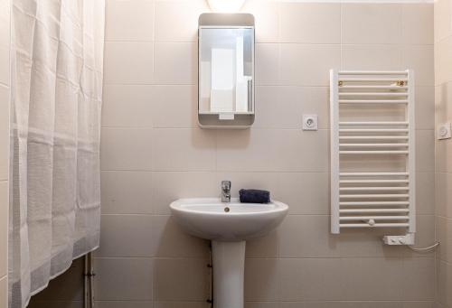 uma casa de banho com um lavatório e um espelho na parede em Le Carteron Annecy em Annecy