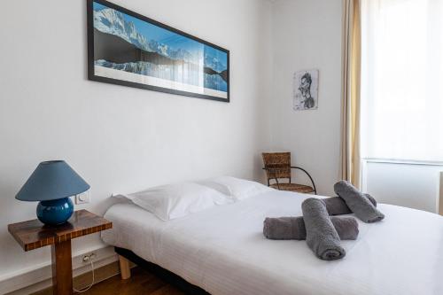 um quarto com uma cama branca e toalhas em Le Carteron Annecy em Annecy