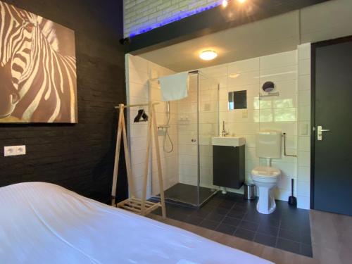 een badkamer met een douche, een toilet en een wastafel bij Bosrijk Ruighenrode in Lochem