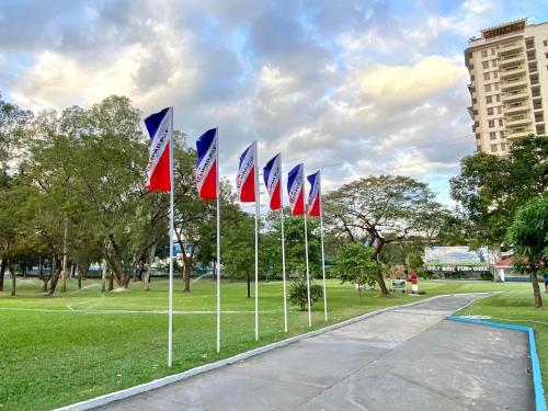 a row of flags on poles in a park at 1BR Condo at Montecito Newport City Residential Resort across NAIA and Marriott Hotel in Manila