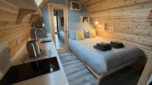 ein Schlafzimmer mit einem Bett in einer Holzhütte in der Unterkunft 21 Callanish Luxury Pod in Callernish