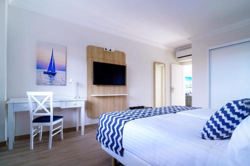 馬西尼古蒂的住宿－Hotel Cordial Marina Blanca，一间卧室配有一张床、一张桌子和一台电脑