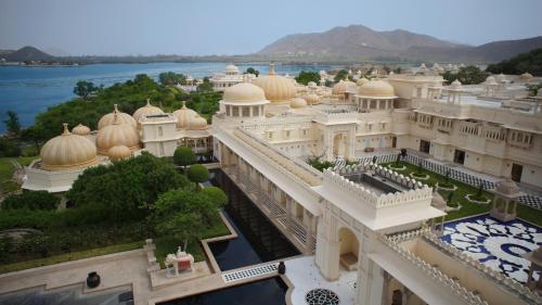 an aerial view of a building with a lake in the background at The Oberoi Udaivilas Udaipur in Udaipur