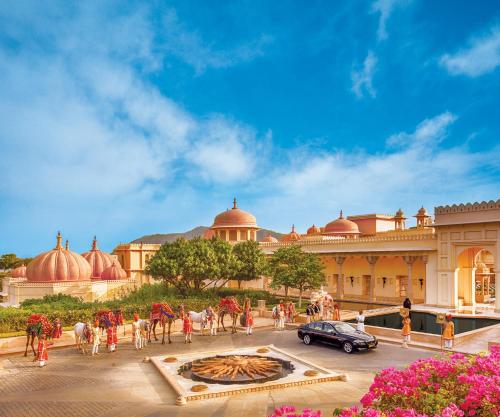 a view of a building with people and horses in front at The Oberoi Udaivilas Udaipur in Udaipur