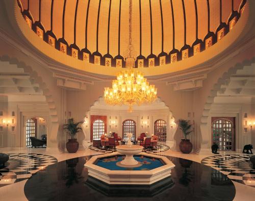 a large lobby with a large chandelier and a fountain at The Oberoi Udaivilas Udaipur in Udaipur