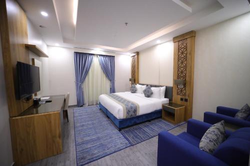 a hotel room with a bed and a flat screen tv at PRIMOTEL Elite As Salamah - Serviced Apartments in Jeddah