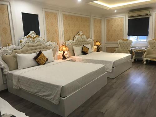 a bedroom with two beds with whiteitures and chairs at THANH TAI HOTEl 1 in Ho Chi Minh City