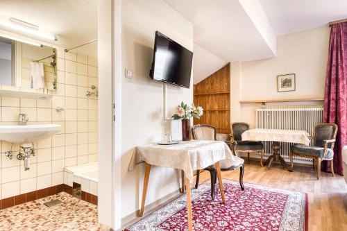 a room with a bathroom with a sink and a table at Ferienhaus Tinabella - bei der Hochjochbahn - Sivretta Montafon in Schruns-Tschagguns