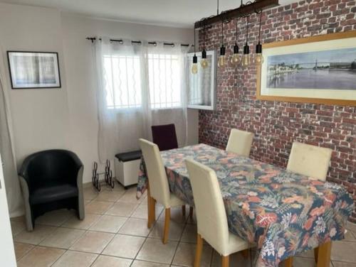 d'une salle à manger avec une table, des chaises et un mur en briques. dans l'établissement Villa Saint Ouen sur Seine, à Saint-Ouen