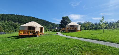 two yurt houses in a field next to a path at 4 Żywioły -całoroczne jurty w Sudetach in Stronie Śląskie