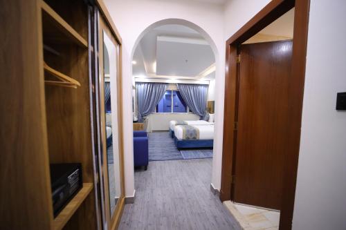 a hallway to a bedroom with a bed and a tv at PRIMOTEL Elite As Salamah - Serviced Apartments in Jeddah