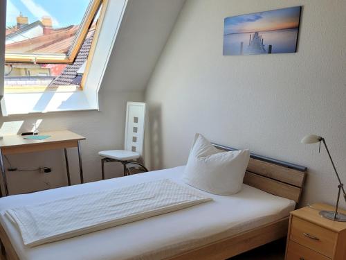 ein kleines Schlafzimmer mit einem Bett und einem Fenster in der Unterkunft Hotel Scheffelhof in Bad Säckingen