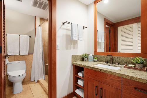 La salle de bains est pourvue de toilettes, d'un lavabo et d'un miroir. dans l'établissement Hanalei Bay Resort 7307, à Princeville