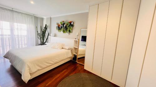 a white bedroom with a bed and a window at VIGO CENTER SEREO OLD TOWN in Vigo