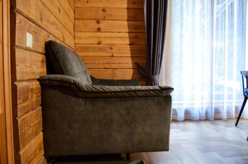 a chair in a room with a wooden wall at Hotel resort Sedula in Skogalis