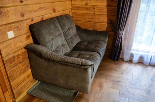 a couch sitting in a room with a laptop at Hotel resort Sedula in Skogalis