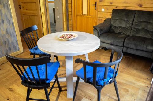 a white table with two chairs and a bowl on it at Hotel resort Sedula in Skogalis