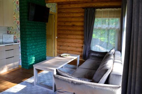 a living room with a couch and a table at Hotel resort Sedula in Skogalis