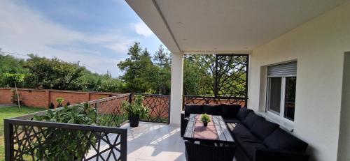a patio with a couch and a table on a balcony at Vila Elena in Niš