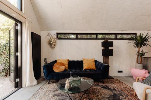 a living room with a blue couch and a glass table at Studio Verver in Bergen