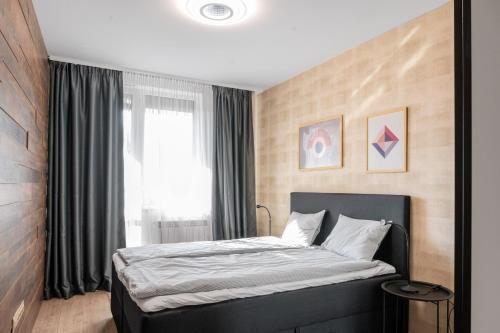 a bedroom with a large bed with a window at Urban Elegance at Its Finest Stylish 1-BD Flat in Sofia