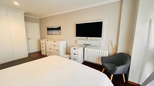 a bedroom with a bed and a tv and a chair at VIGO CENTER SEREO OLD TOWN in Vigo
