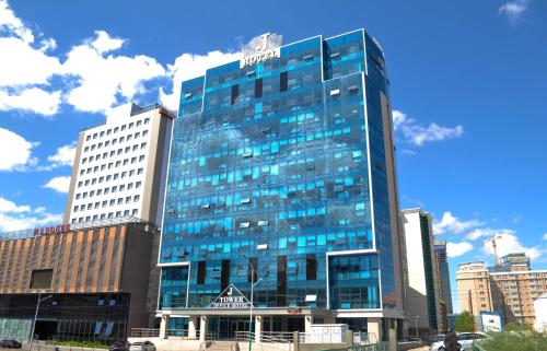 un edificio de cristal alto con un cartel encima en J Hotel en Ulán Bator