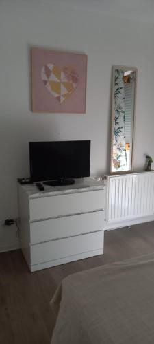eine weiße Kommode mit einem Fernseher darüber in der Unterkunft Beau appartement T3 in Montpellier