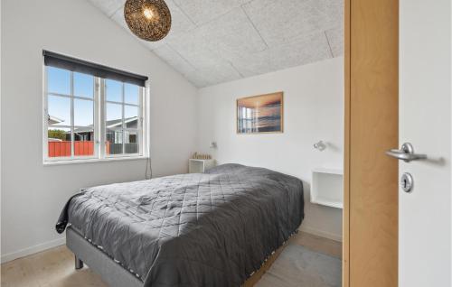 Schlafzimmer mit einem Bett und einem Fenster in der Unterkunft Pet Friendly Home In Hvide Sande With Sauna in Hvide Sande