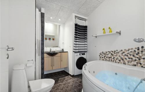 ein Badezimmer mit einer Badewanne, einem WC und einem Waschbecken in der Unterkunft Pet Friendly Home In Hvide Sande With Sauna in Hvide Sande