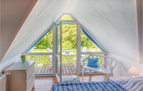 Schlafzimmer im Dachgeschoss mit einem Bett und einem Fenster in der Unterkunft 2 Bedroom Gorgeous Home In Boiensdorf in Boiensdorf